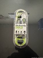 Front view of sealed Skullcandy Ink'd headphones packaging showing earbuds and Skullcandy branding