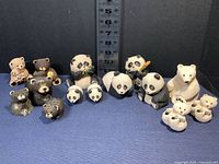 Full collection of 13 hand carved bear figurines showing various sizes and types including black bears, pandas, and polar bears with a ruler for scale.
