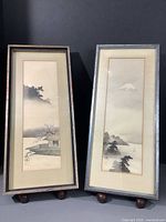 Both framed paintings standing, shown to illustrate full lot and comparison