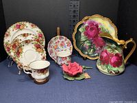 Sampler tea set and porcelain rose figurine arrangement with plates, cups, saucers, Limoges pitcher and platter with floral rose patterns