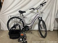 Full side view of Trek 16.5 inch silver step-through bicycle with accessories placed in front, showing overall condition and setup.