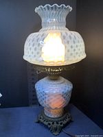 Large vintage opalescent hobnail lamp with detailed ruffled glass shade and ornate metal base, illuminated and plugged in to show working condition.