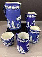 Overview photo of all 5 pieces showing cobalt blue jasperware with white classical bas-relief decorations and grapevine pattern border