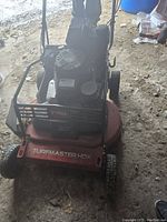 Front view of mower showing red deck, Toro logo on front guard and Turfmaster HDX label