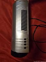 Front view of the silver and black Bionaire electric heater fan showing ventilation grille and control buttons.