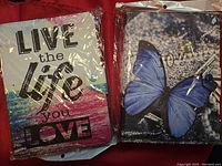 Photo showing two brand new tablet cases still in plastic packaging, one with motivational text, another with butterfly print.