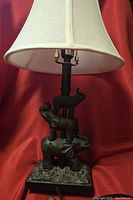 Full view of the elephant lamp showing the stacked elephant base and white fabric shade.