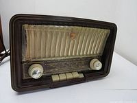 Front and angled view of the vintage tube radio showing casing, grille, and control knobs