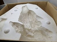 Photo showing the top part of the white ceramic mold with wolf head and fur details.