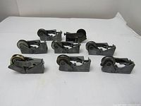 Front angle view of all eight patio door sliding door roller assemblies with 1.25 inch diameter wheels arranged on white surface showing new to used condition.