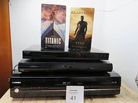 Stacked electronics with two VHS tapes Titanics and Gladiator on top