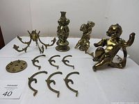 Photo of all vintage lamp parts arranged on a flat surface showing cherubs, curved arms, base, and lamp stem.
