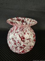 Front view of the vase showing cranberry and white swirl diamond pattern with ruffled rim.
