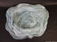 Top view of large decorative glass fruit bowl with aqua and white swirl.