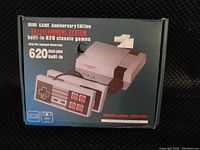 Closed box of the mini game system showing product image, details about 620 classic games, and controls.
