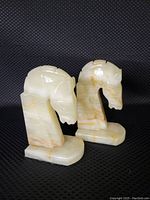 Front-side view of both onyx horse head bookends showing detailed carving and polish.