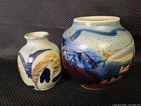 Pair of stoneware clay vases, one large with blue-red beige glaze, one smaller with blue-brown design.