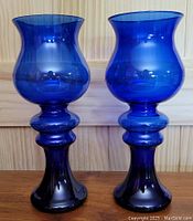 Full view of the pair of cobalt blue crystal vases showcasing their color and spool shape.
