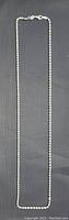 Full length view of the silver box chain necklace against a black background, showing the clasp and length.