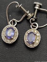 Close-up image of the front side of the vintage 14K gold earrings showing oval Dyach Tanzanite stones surrounded by small diamonds with screw back clasps.