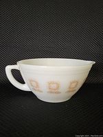 Front and side view of the white milk glass batter bowl showing overall shape, handle and spout.