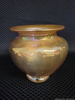 Front angled view showing the iridescent brown blown glass vase with flared lip and bulbous body.