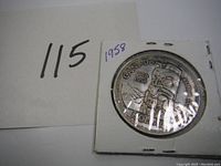 Obverse side of the 1958 Canadian silver dollar featuring a totem pole design.