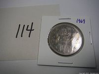 Front side of the 1969 Voyageur Silver Dollar Coin, showing the canoe and voyageurs with date and denomination.