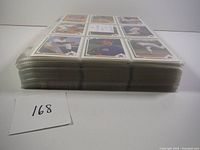 Side view of thick stack of baseball cards organized in protective sheets to show quantity of cards
