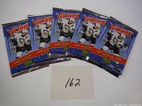Five unopened 2006-2007 Upper Deck Victory hockey card packs arranged side by side, showing the front design with a hockey player image.