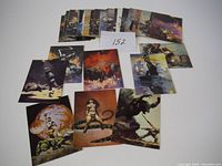 Lot of 50 assorted Frank Frazetta style fantasy art prints, arranged in groups and close-ups showing detailed artwork and vibrant color palettes.