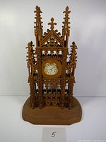 Front view of wooden fretwork clock showcasing intricate scroll saw pattern and clock face.