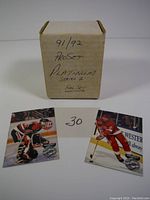 Original small cardboard box with handwritten label '91/92 Pro Set Platinum Series 2 Full Set' and two hockey cards displayed in front of it on a white surface. The cards depict hockey players in action with the Pro Set Platinum Series 2 logo visible.