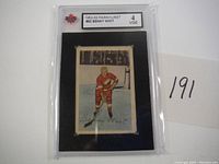 Front encapsulated view of 1952-53 Parkhurst Benny Woit hockey card graded 4 VGE showing player in red uniform
