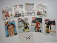 Full view of nine 1977-78 Topps hockey cards arranged in two rows on white surface with identifying lot number 145