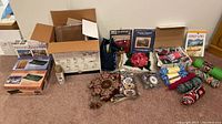Wide view of all craft materials and puzzles showing boxes, yarn, plastic canvases and needlepoint items spread on floor.