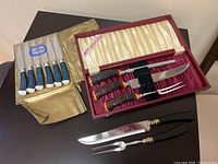 Photo showing both cutlery sets including box for six-piece set and three-piece Kirks set with brown bone handles.