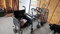 Overall shot showing wheelchair, four-wheeled walker, two-wheeled walker, and crutches together against garage background