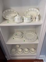 Photo shows shelves with all Minton Ariel dishes including plates of various sizes, teacups, saucers, cream jug, covered sugar, and salt and pepper shakers.