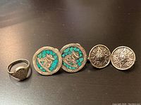 Front view of the two pairs of sterling silver earrings with a ring placed beside them, showing turquoise inlay on one pair and detailed engraving on the other.