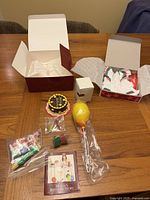 Full view of all items from Molly's Party Treats including cake, candles, presents, balloon, flowers, and booklet alongside the party dress box opened revealing the dress