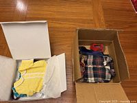 Box opened showing plaid shirt, roller skates, and red helmet inside smaller box.