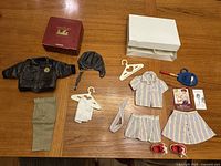 Full view of both Molly doll outfits and accessories laid out on table with original box packaging visible.