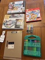 Photo of all items together showing kit boxes, palettes, pens, markers, sketch board
