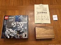 Novica wooden puzzle box with instructions on table beside LEGO box