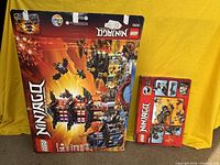 Temple of Airjitzu and Rock Roader boxes displayed side by side against a yellow backdrop