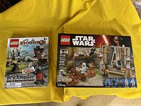 Photo showing the Lego Castle Brickmaster book and Lego Star Wars Battle on Takodana set in unopened box placed on a yellow background.