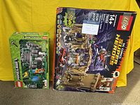 LEGO Minecraft The Jungle Temple and LEGO Batman Batcave boxed sets shown upright on yellow background
