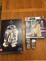 Overview of two sealed Lego Star Wars sets and two Grogu Tervis tumblers arranged on a wooden table