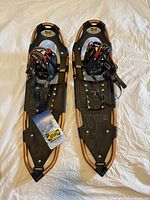 Full top view of pair of black and gold Atlas Series 10 men's snowshoes size 30 with bindings and tags visible.